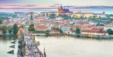 Prague bridge across river with town in background.